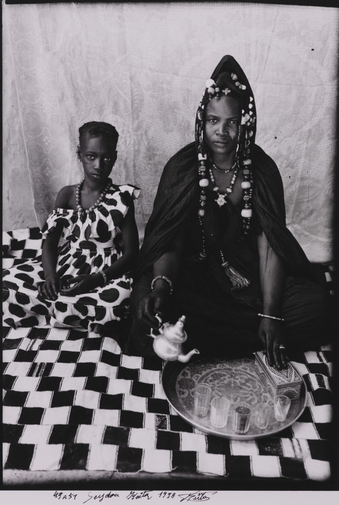 A Moorish Haratine Woman Posing With Her Daughter On A Chequered Blanket